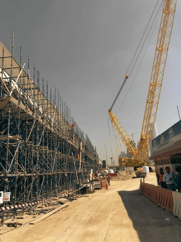 A crane working alongside erected scaffolding on an RTL site